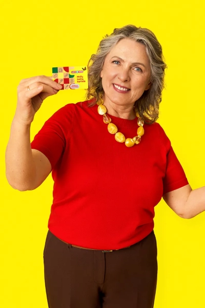 „Camelia“ senjorų reklaminės kampanijos vertikalus vizualas su senjorų pora ir nuolaidų pasiūlymais.